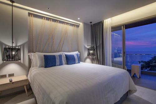 a bedroom with a large bed and a large window at U Jomtien Pattaya in Jomtien Beach