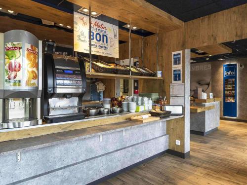 un restaurant de restauration rapide avec un comptoir avec de la nourriture dans l'établissement ibis budget Saint Pourcain, à Saint-Pourçain-sur-Sioule