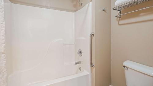 ein Badezimmer mit einer Dusche und einer weißen Badewanne in der Unterkunft Best Western Wittenberg Inn in Wittenberg