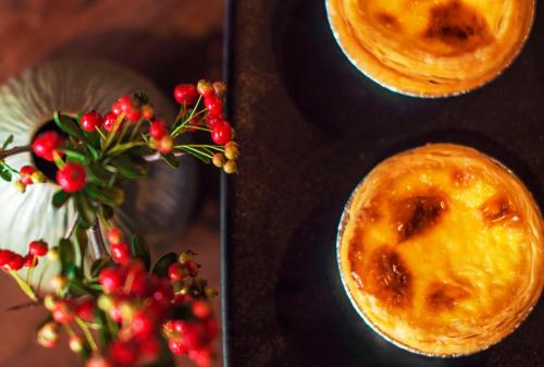 two pastries on a table next to a vase with berries at Yakamoz Erhai Hotel in Dali