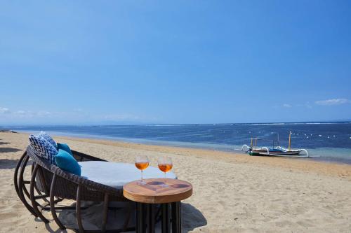 two glasses of wine sitting on a table on the beach at Hyatt Regency Bali in Sanur