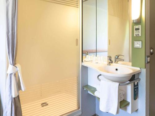 uma casa de banho com um lavatório e um chuveiro em ibis budget Saint Pourcain em Saint-Pourçain-sur-Sioule