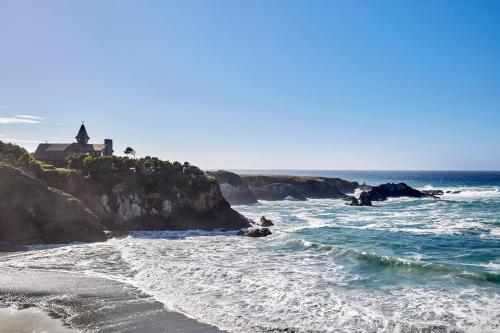 a view of a beach with a lighthouse and the ocean at Oceanfront Home - Stunning Views & Private Hot Tub in Fort Bragg