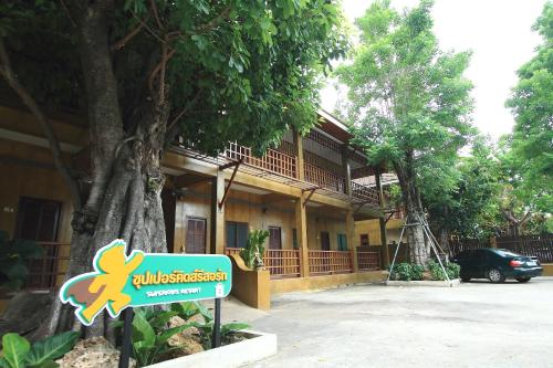 a sign in front of a building with a tree at Superkids Resort in Phitsanulok