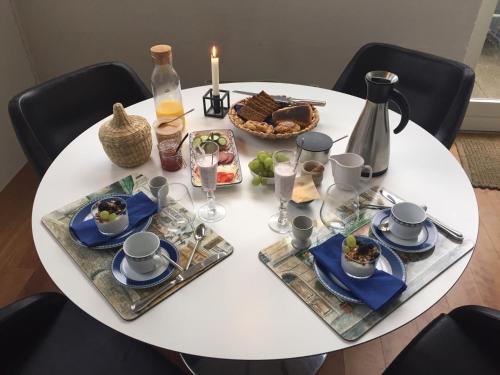 einen weißen Tisch mit einem Teller Essen drauf. in der Unterkunft Brøndums Bed & Breakfast in Hjørring