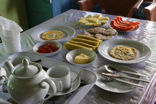 una mesa con platos de comida y una tetera en Sandu Guest, en Mirissa