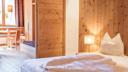 a bedroom with a bed and a wooden wall at Biohotel theiner's garten in Lana