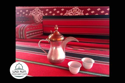 a tea kettle and two cups on a table at Wadi Rum Moon Light Camp in Wadi Rum