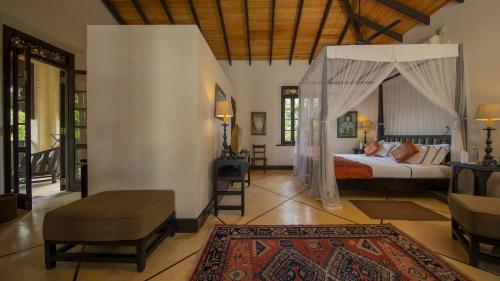 un dormitorio con una cama con dosel en Sergeant House Boutique Villa & Private Beach, en Unawatuna