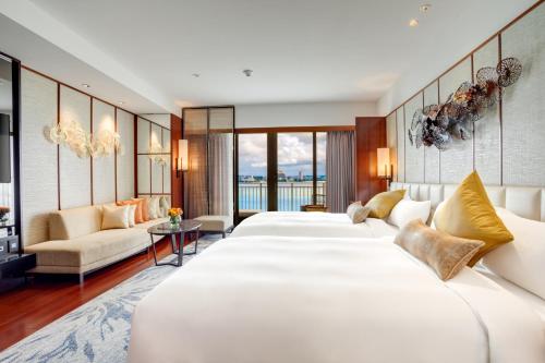 a hotel room with three beds and a living room at The Tsubaki Tower in Tumon