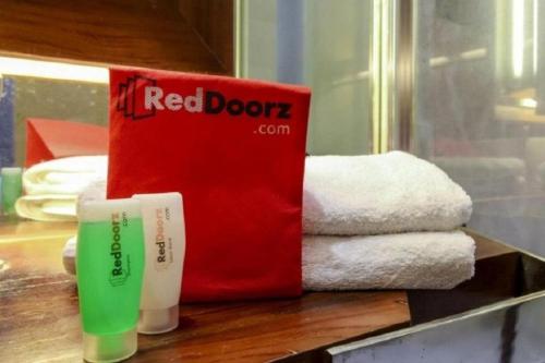 ein rotes Buch und ein paar Handtücher auf der Theke in der Unterkunft RedDoorz @ Galuh Mas in Karawang