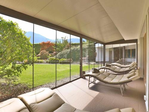 a living room with a couch and large windows at Biohotel theiner's garten in Lana
