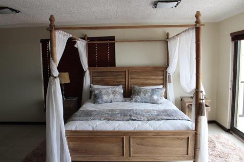 1 dormitorio con cama con dosel y cortinas blancas en Zee Sicht, en Swakopmund