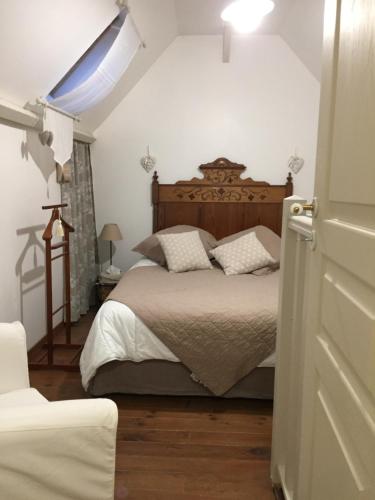 um quarto com uma cama e uma cabeceira em madeira em Gîte du Rouard em Camiers