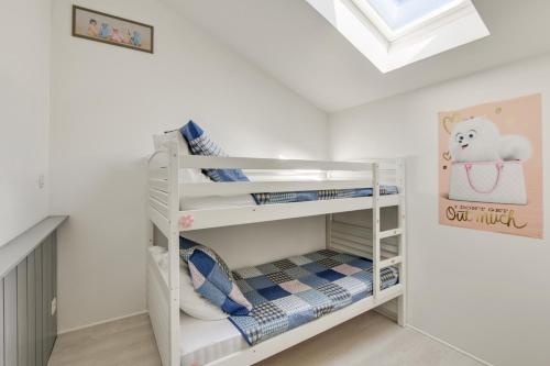 Ce lit superposé blanc se trouve dans un dortoir doté d'un plafond. dans l'établissement Appartement Bassin, à Arès