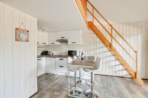 une cuisine avec des armoires blanches et une table dans l'établissement Appartement Bassin, à Arès