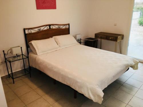 een slaapkamer met een groot wit bed en 2 tafels bij Mi Tiempo in Muntanya la Sella