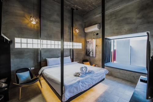 a bedroom with a bed and a chair and a window at Color Coral Boutique Hotel in Magong
