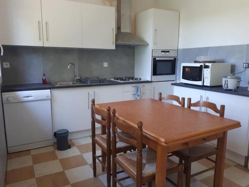 Il comprend une cuisine avec une table et des chaises en bois. dans l'établissement Location de vacances à Gourdon en Bouriane (46), à Gourdon