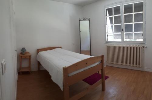 une chambre avec un lit en bois et une fenêtre dans l'établissement Location de vacances à Gourdon en Bouriane (46), à Gourdon