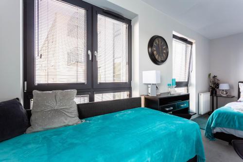 a bedroom with a bed and a clock on the wall at Luxury Apartment with Large Terrace in Wrocław