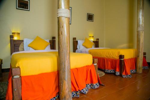 מיטה או מיטות בחדר ב-Lake Mulehe Gorilla Lodge