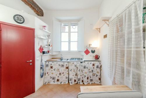 una cucina con porta rossa e finestra di Red Passion a Cernobbio