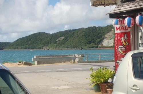 a car parked on a road next to a body of water at 東のオズ in Higashi