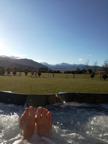 a person with their feet in a jacuzzi tub at Kepler Oaks Chalet in Te Anau