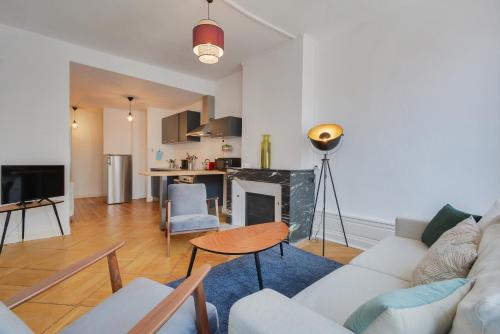 un salon avec un canapé et une cheminée dans l'établissement Le Cœur des Dominicains - pour 6 centre de Nancy, à Nancy