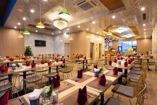 a dining room with tables and chairs and a tv at Lucky Sun Hotel in Nha Trang