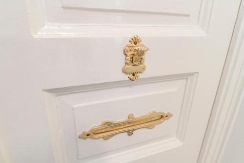 a gold door handle on a white door at The Ring Suites in Graz
