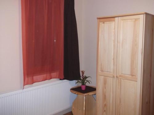 a room with a window and a table with a plant at Napfénydomb Vendégház in Mátraszele