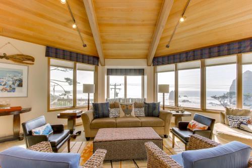 a living room with a couch and chairs and windows at Haystack Views Vacation Rental in Cannon Beach