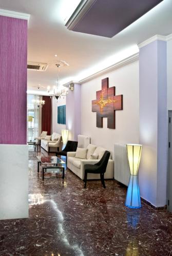 a living room with a couch and a cross on the wall at Hotel Bakos in Loutraki