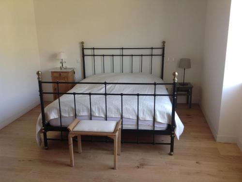 - une chambre avec un lit, une chaise et un tabouret dans l'établissement Au Pied des Vignes - Maison au Coeur du Vignoble, à Santenay