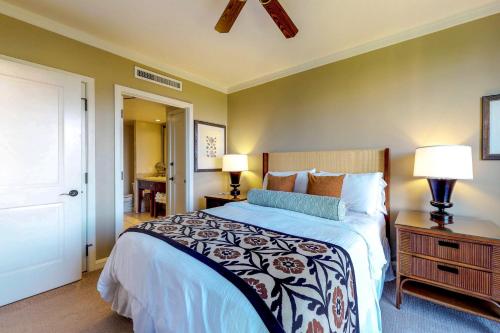 a bedroom with a large bed and two lamps at Honua Kai - Konea 738 in Lahaina