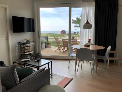 een woonkamer met een tafel en uitzicht op de oceaan bij Superfint boende med havsutsikt, Tofta Strand in Visby