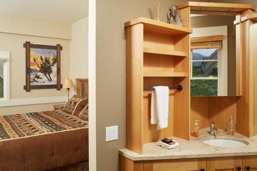 a bathroom with a sink and a bedroom with a bed at Saddle Ridge Townhome G-2 in Big Sky