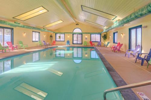 a large indoor swimming pool with red chairs and tables at Winterplace G101 in Ludlow