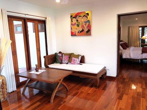 a living room with a couch and a table at Jasmine Hills Lodge in Doi Saket