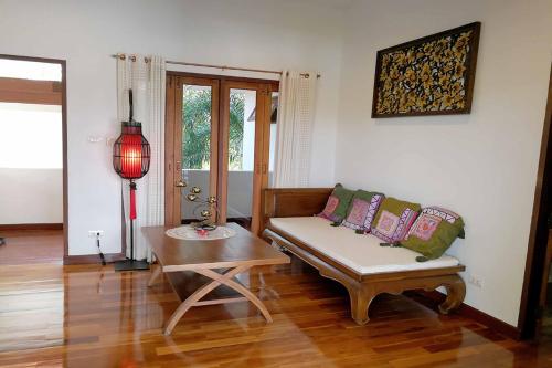 a living room with a couch and a table at Jasmine Hills Lodge in Doi Saket