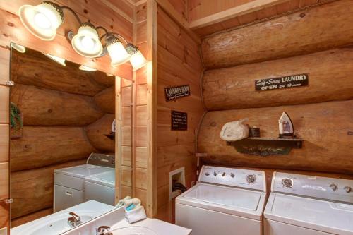 a bathroom with a washer and dryer in a cabin at Chief Big Log Cabin in Hatchertown