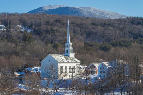 a church with a steeple on top of a town at Cozy Stowe Retreat in Stowe