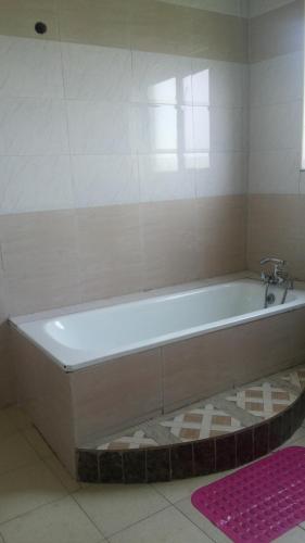 a bath tub with a faucet in a bathroom at Victoria Panorama Hotel in Jinja