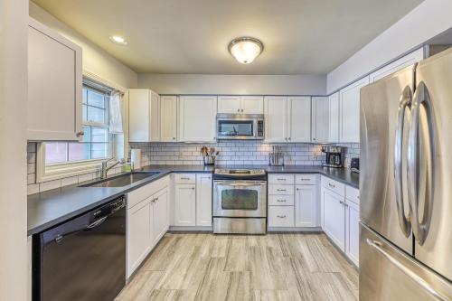 a kitchen with white cabinets and stainless steel appliances at Cozy Stowe Retreat in Stowe