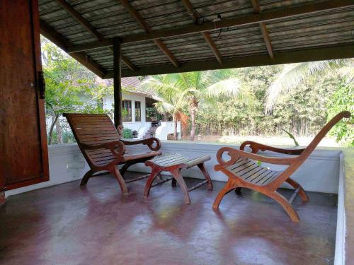 two rocking chairs and a bench on a porch at Jasmine Hills Lodge in Doi Saket