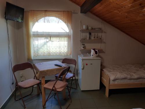 uma pequena cozinha com mesa e cadeiras e uma janela em Penzion Cerhenice em Cerhenice