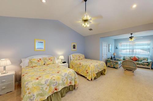 a bedroom with two beds and a couch at Dream in the Keys in Key Colony Beach