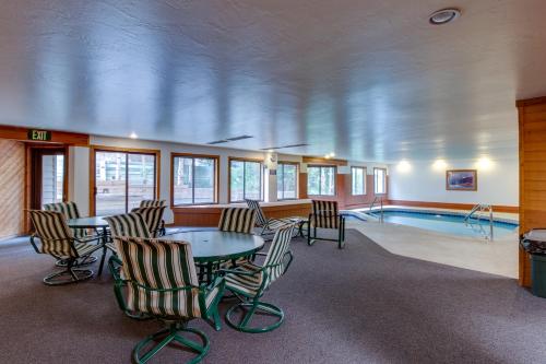 a pool room with chairs and a table and a swimming pool at Snowdance Manor 205 in Keystone